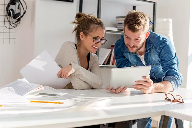 Couple étudiant des plans de maisons